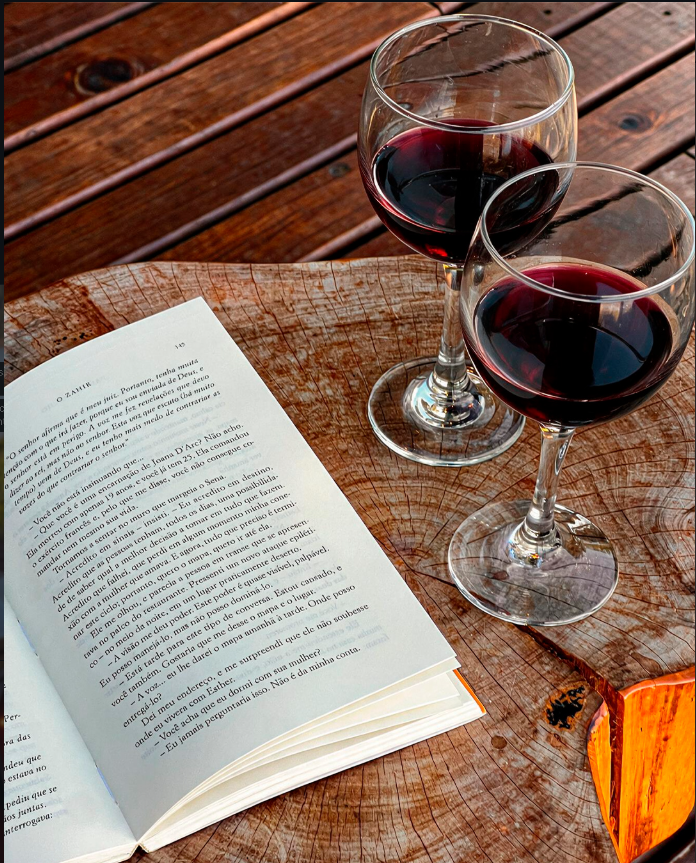 Taças de vinho e livro sobre a mesa de madeira