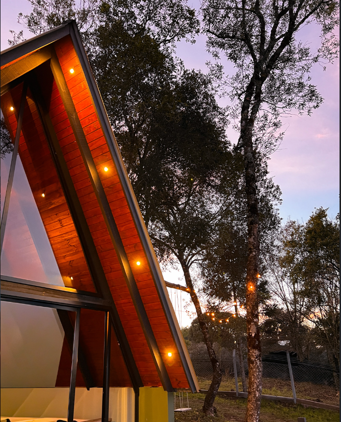 Cabana iluminada ao anoitecer entre as árvores